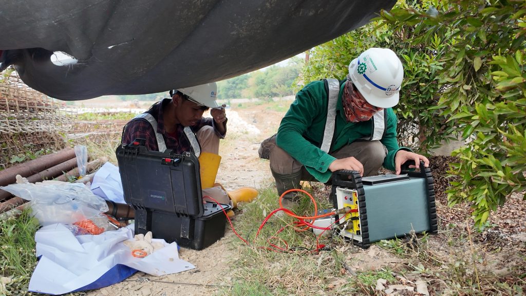 Survei geolistrik air tanah menggunakan instrumen multi-elektroda di lapangan.